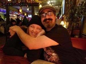 two people in a restaurant hugging while they both smile