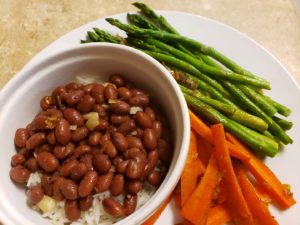 a plate of rice and beans and sauteed vegetables