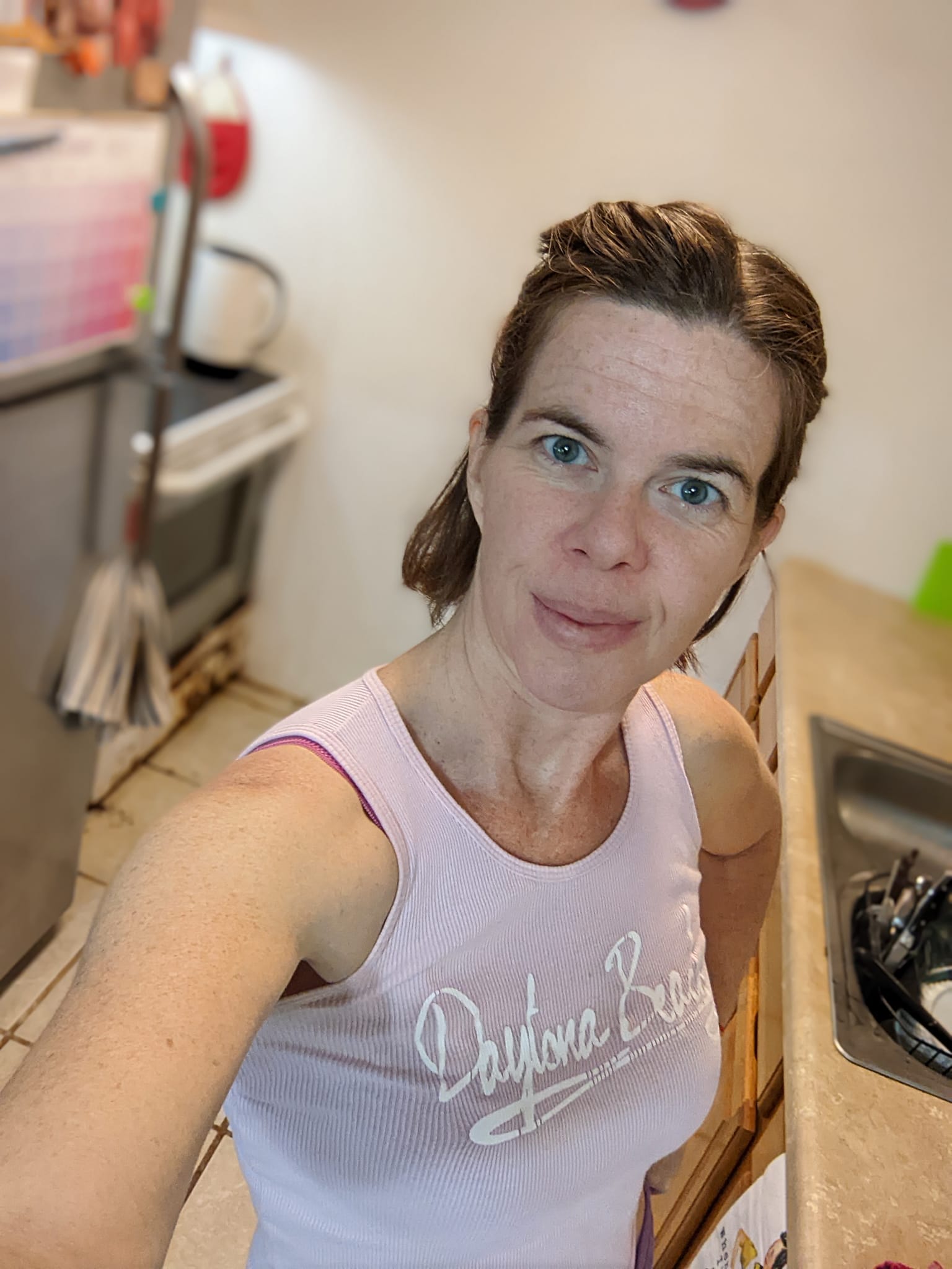 selfie in a kitchen with white walls and a really old stove