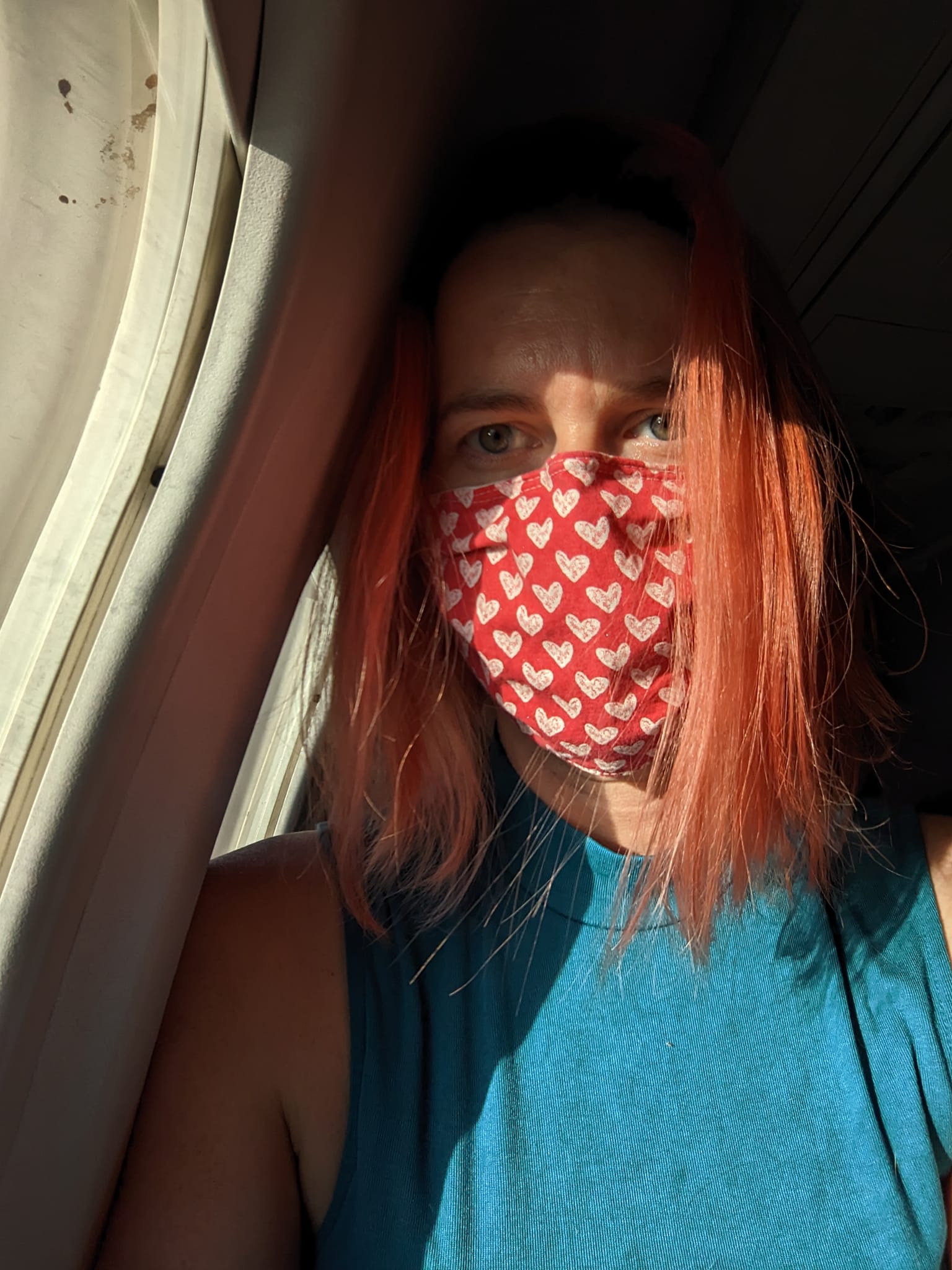 selfie wearing a cloth mask next to an airplane window
