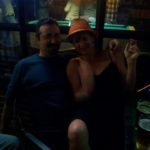 a dark scene on a bar patio where two people are sitting and talking