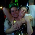 two women dressed for new year's celebrations are hugging