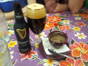 a colorful table cloths with a beer and several empty dishes on it