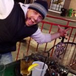 a person makes and excited face over a tray of drinks on a bar patio