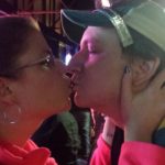two people kiss for new year in a dark bar