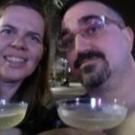 a blurry selfie of two people holding champagne glasses