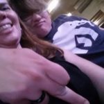 selfie of two people at an awkward angle with one flipping his middle finger