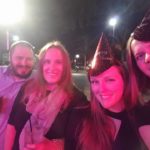 a group of new years eve partiers pose for a photo on a city scene