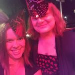 a selfie of two people in new years hats under strong red light