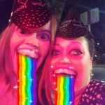two people take a selfie with a filter that makes it look like rainbows are pouring out oif their mouths