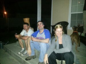 several people sitting casually on porch steps in the dark