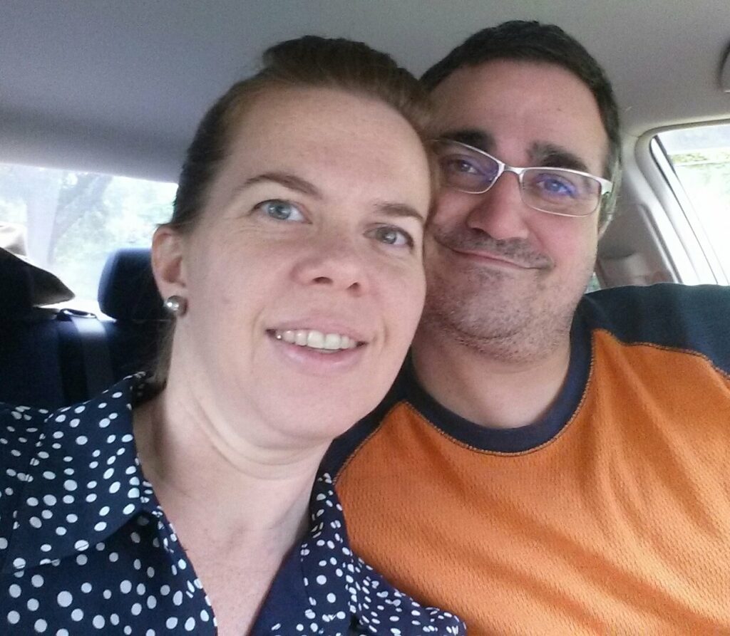 selfie of a couple staring into the camera somewhat tired and she is dressed up while he is casual