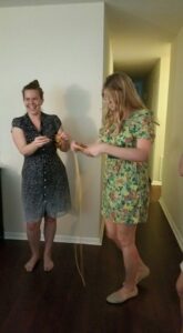 two people stand in a hallway in bare feet laughing over something they are holding