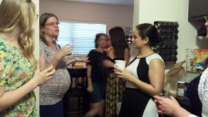 a group of people talking in a house with one very pregnant