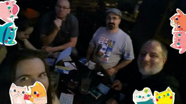 a very dark group shot at a pub table with stickers overlayed on the picture