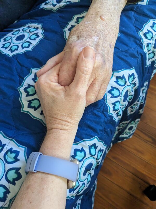 two hands holding, one significantly older than the other