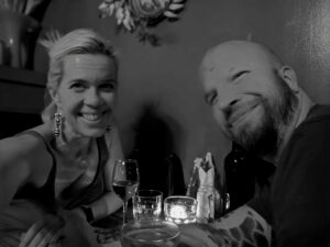 black and white selfie of two people at a small dinner table