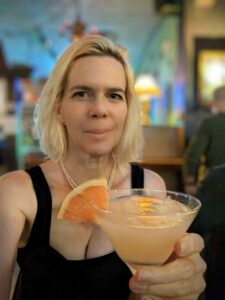 a selfie in a restaurant with a cocktail with a wedge of grapefruit on the rim