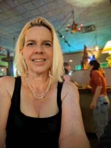 a selfie at a restaurant with blurry people talking in the background