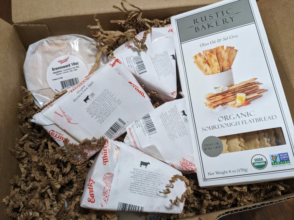 a gift box with several types of cheese and crackers