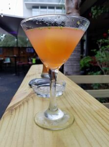 a martini glass of cloudy peach drink