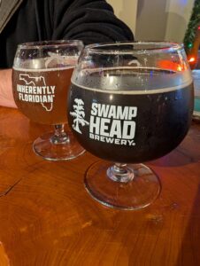 two goblet glasses of craft beer with a logo and Swamp Head on them
