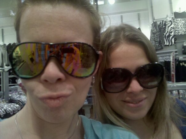 a selfie of two people in a store wearing big sunglasses