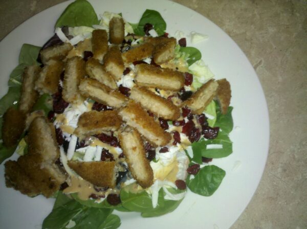 a somewhat blurry picture of a plat of salad and possibly chicken