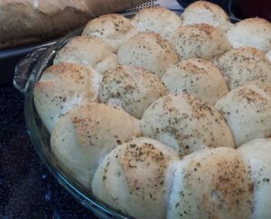 close up of a pan of baked roles with herbs on top