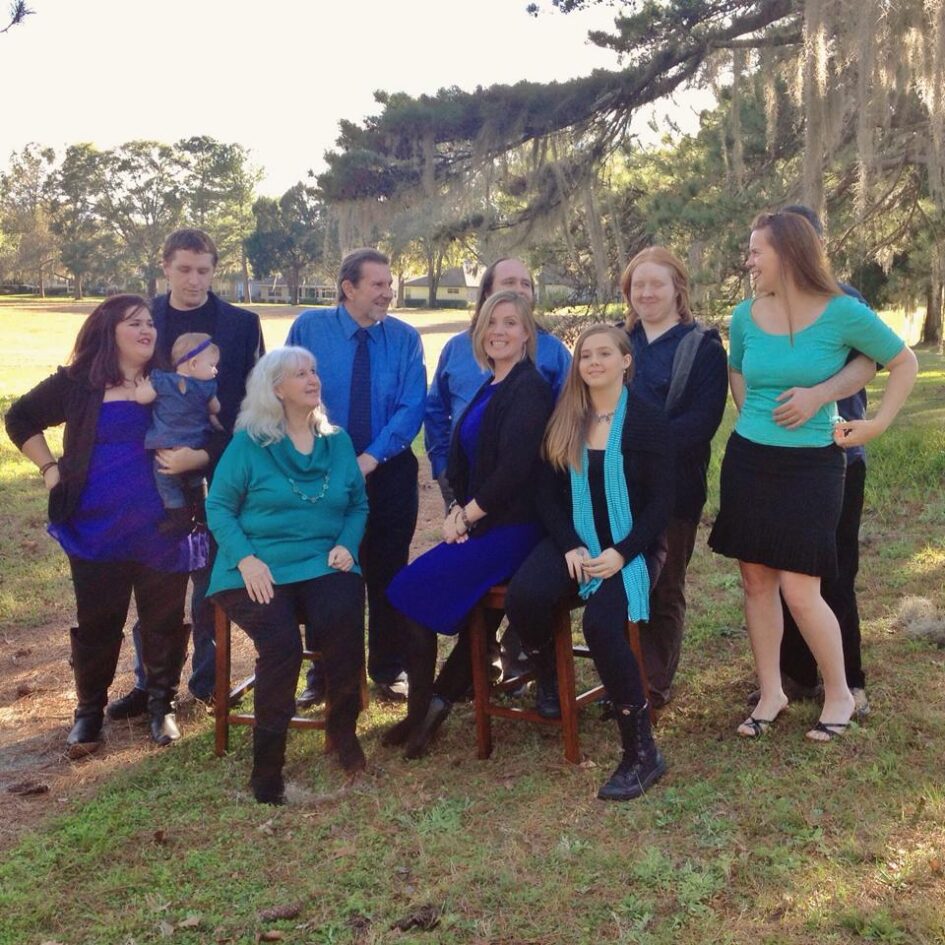 a family of ten in matching clothes are posting for a portrait
