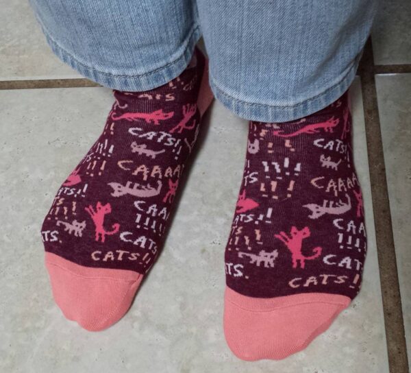 a shot of dark socks on feet with a cat pattern on them