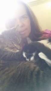 a blurry picture of someone holding two sleeping cats