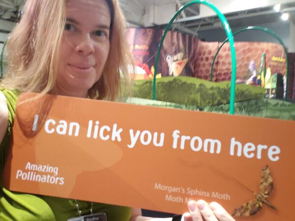 a person is holding a printed sign that says 'I can lick you from here' with a picture of a bug on it