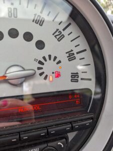 close up of a car's dash showing the fuel gage is nearly empty