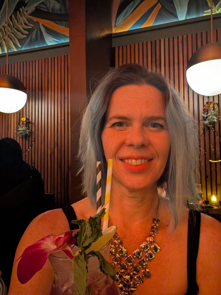 a selfie of a person holding a fancy tiki drink