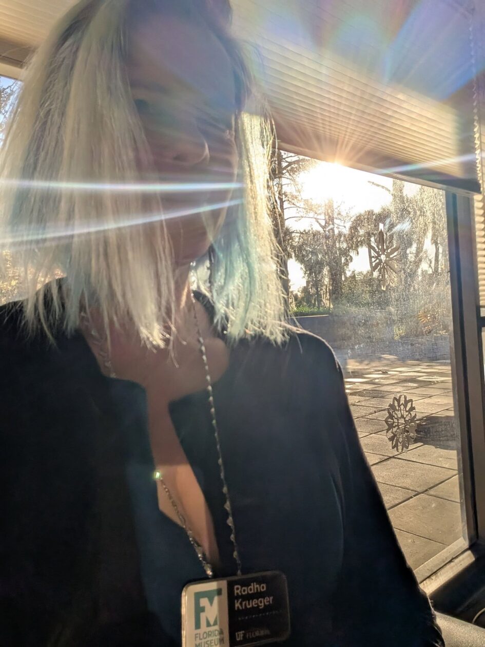 selfie of a person with the sun piercing the window behind them