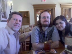 three people are seated at a table in a restaurant