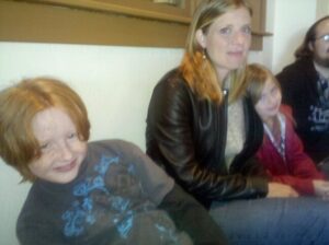 a blurry picture of a parent sitting on a bench flanked by two kids