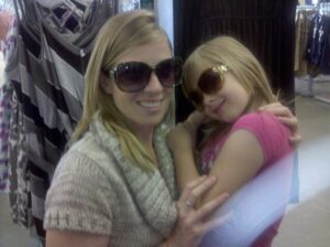 a mother and daughter are posing for the camera wearing very large sunglasses in a clothing store
