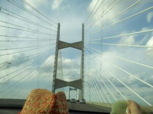 a highway runs between tall pillars and beams with a web of suspension cables as if this is a big bridge