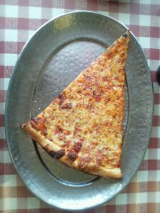 a slice of pizza on a metal plate
