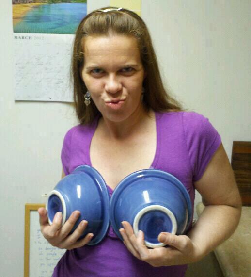 a person is holding up two big blue bowls over their breasts and making a duck face
