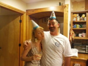 two people in birthday hats in a kitchen