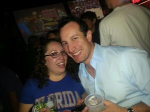 two people in a crowded bar are posing for a photo