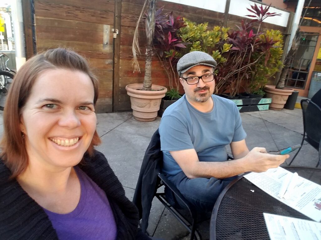 two people are sitting at a restaurant patio table