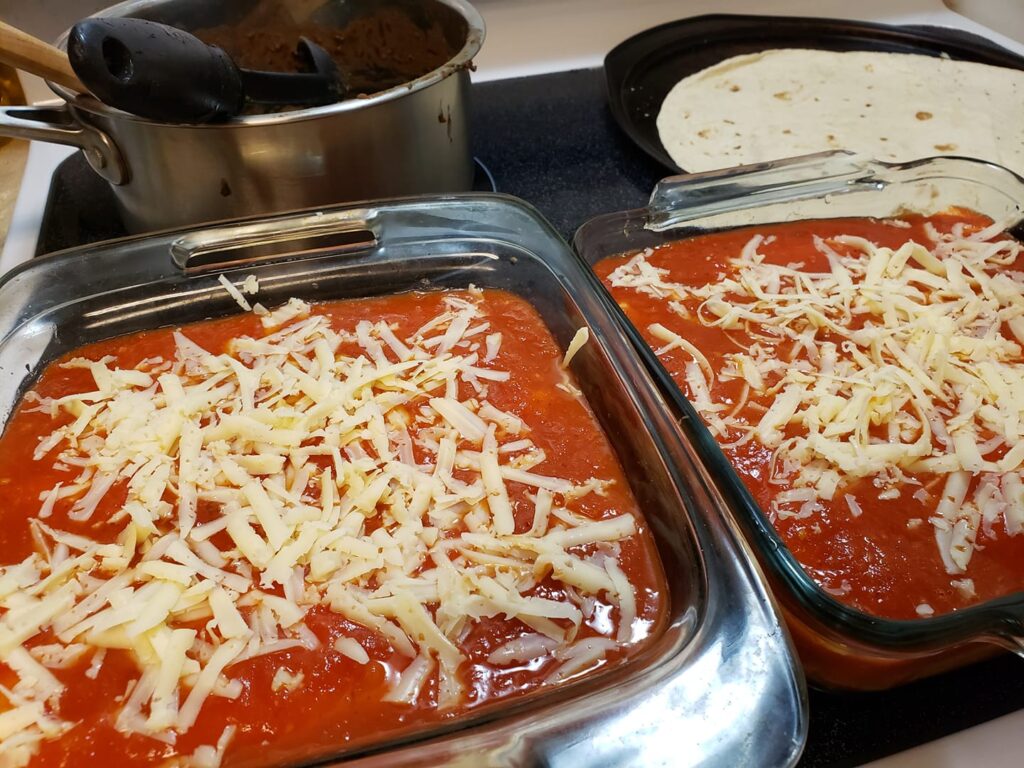 two casserole dishes with red and shredded cheese