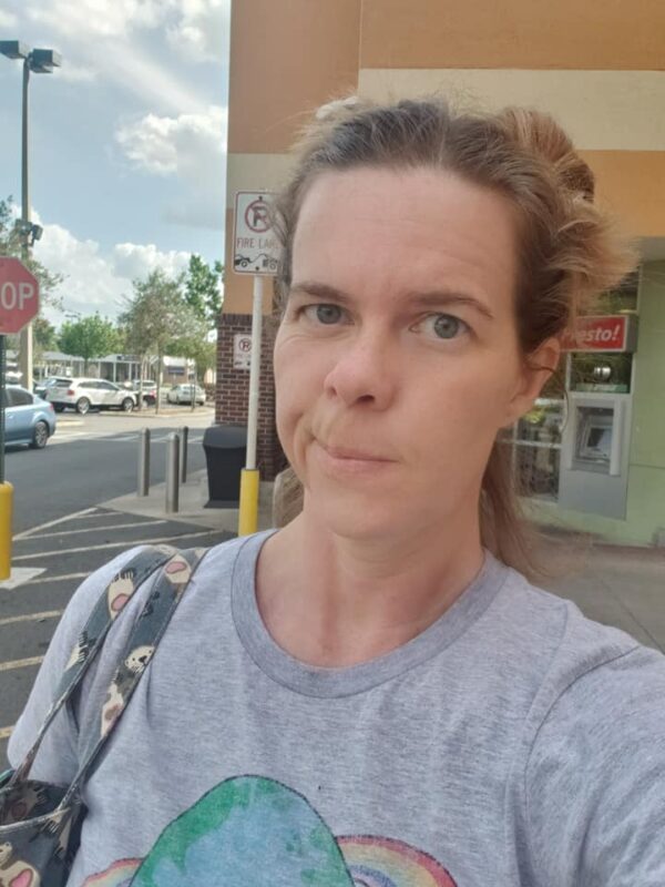 selfie of an unamused person outside a grocery store
