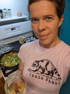 selfie of a person with a wine glass and a stove in the background