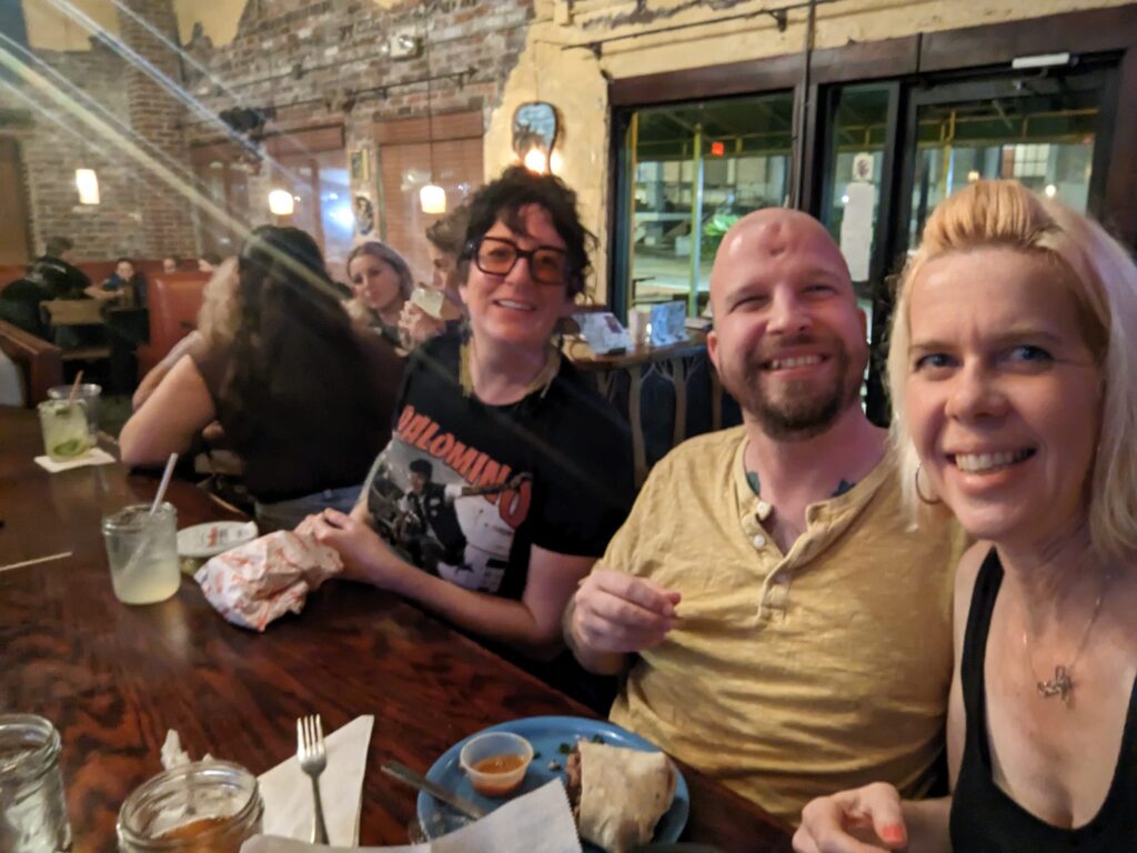 three people are sitting at a bar in a restaurant