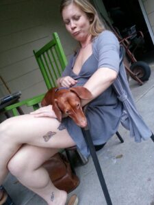 a person sitting on a porch holding a small dog